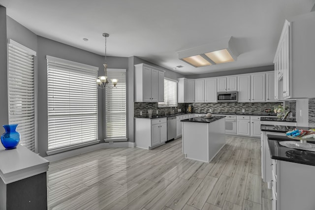 kitchen featuring decorative backsplash, a center island, white cabinetry, and stainless steel appliances