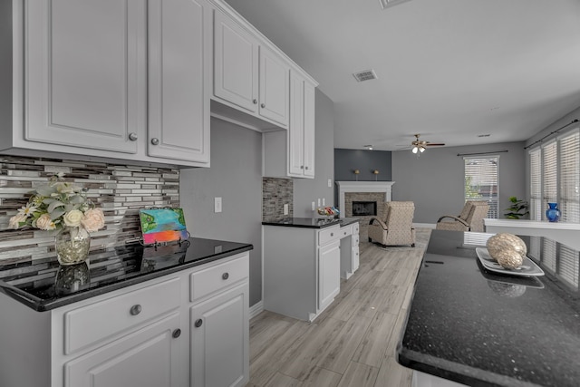 kitchen featuring white cabinets, ceiling fan, light hardwood / wood-style floors, and tasteful backsplash