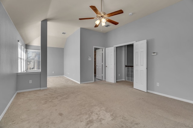 unfurnished bedroom with ceiling fan, light colored carpet, and vaulted ceiling