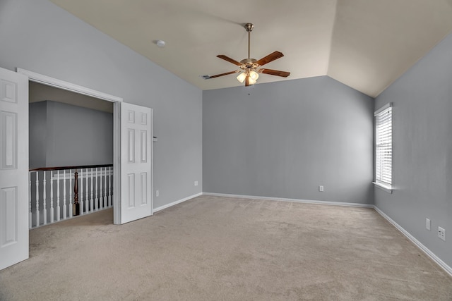 carpeted empty room with ceiling fan and lofted ceiling