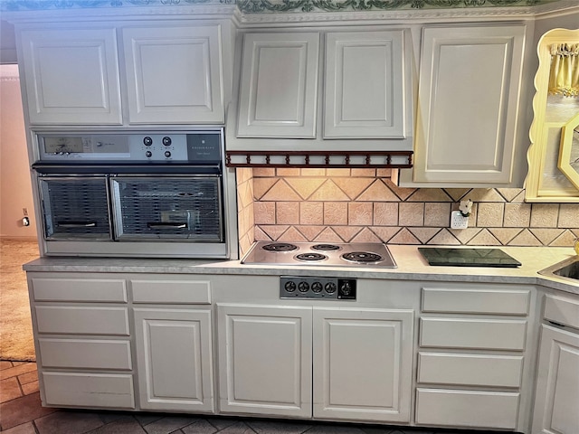 kitchen with white cabinets, backsplash, oven, and stainless steel electric stovetop