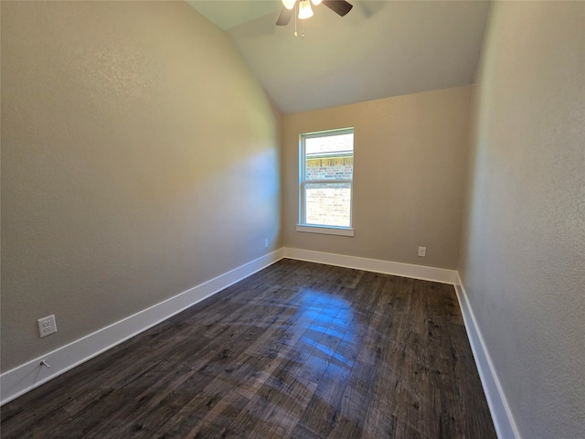 empty room with ceiling fan, lofted ceiling, and dark wood-type flooring