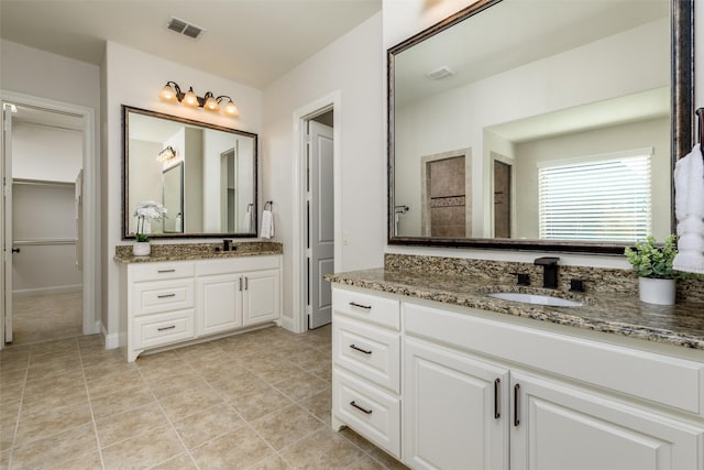 full bathroom with two vanities, visible vents, a sink, baseboards, and tile patterned floors