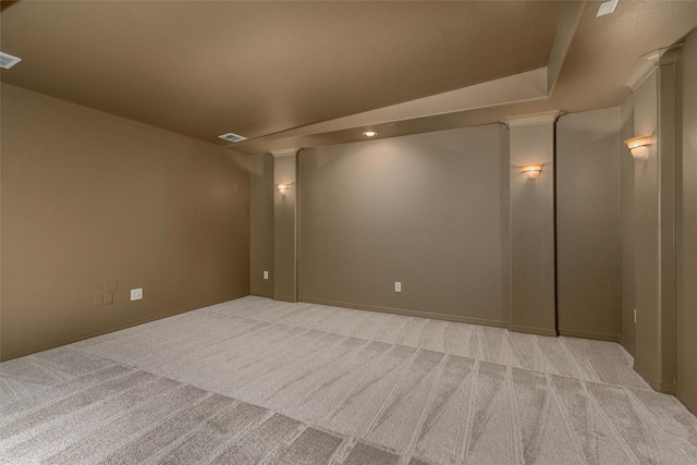 empty room with baseboards, visible vents, and light colored carpet