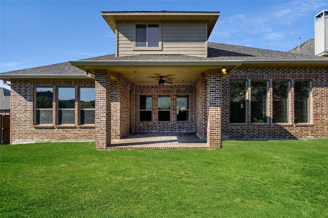 back of property featuring brick siding, a yard, a shingled roof, a ceiling fan, and a patio area