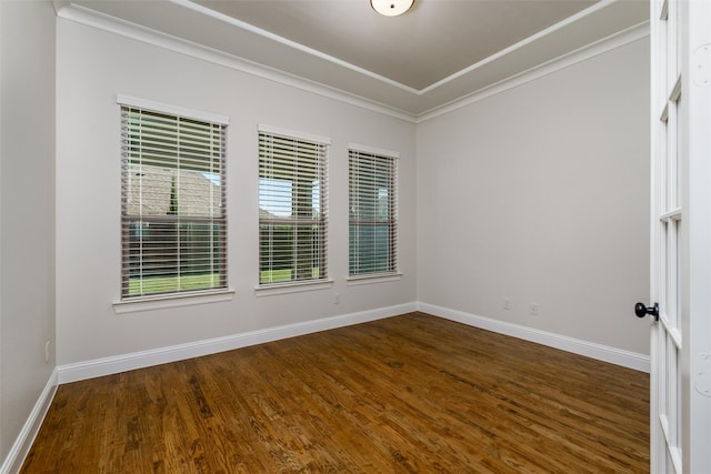 spare room with ornamental molding, baseboards, and dark wood-style floors