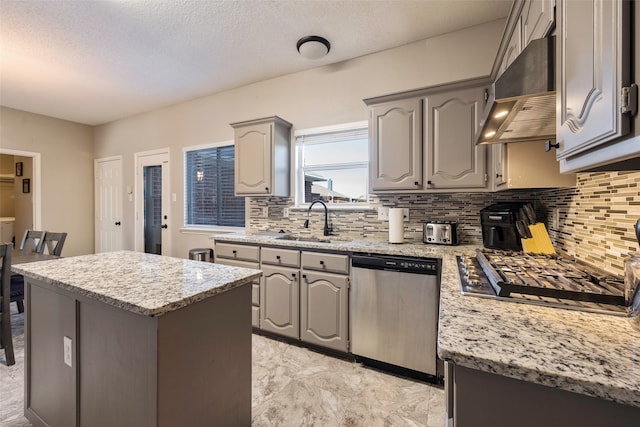 kitchen with sink, decorative backsplash, gray cabinets, light stone counters, and stainless steel appliances