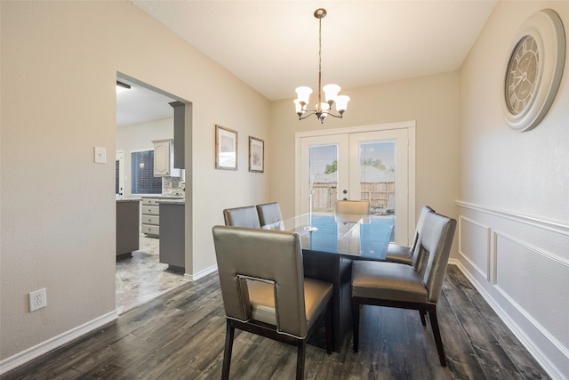 dining room with french doors, dark hardwood / wood-style flooring, and an inviting chandelier