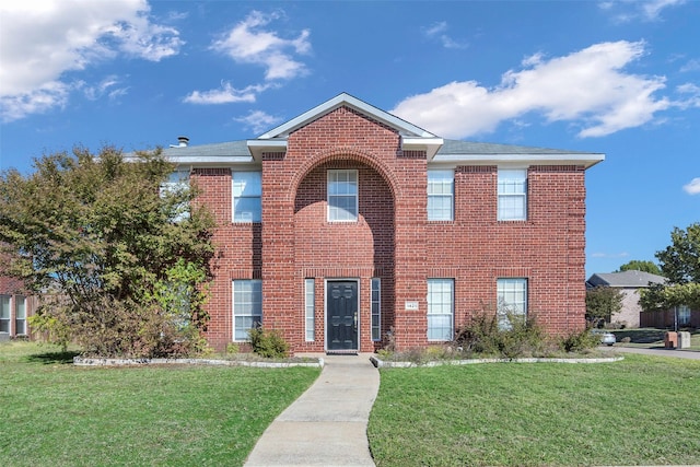 view of front of property with a front yard and brick siding