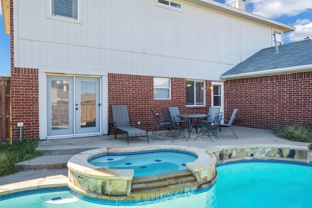 exterior space featuring a swimming pool with hot tub and a patio area