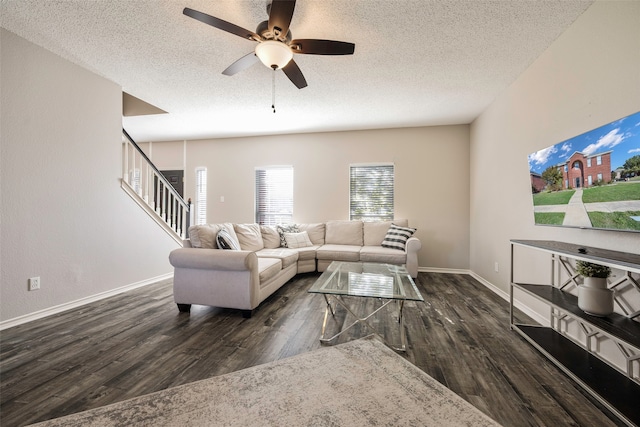 living room with ceiling fan, dark hardwood / wood-style flooring, and a textured ceiling