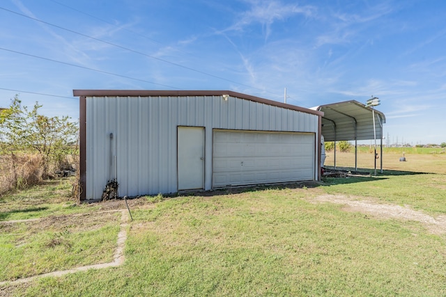 garage with a carport and a lawn