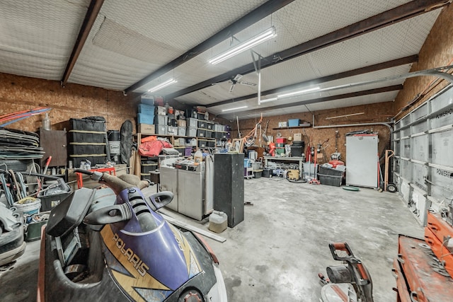 garage featuring a workshop area and white refrigerator