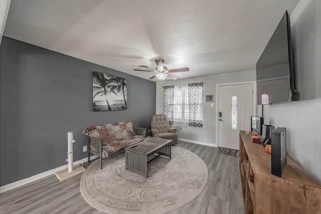 living room with wood-type flooring, a textured ceiling, and ceiling fan