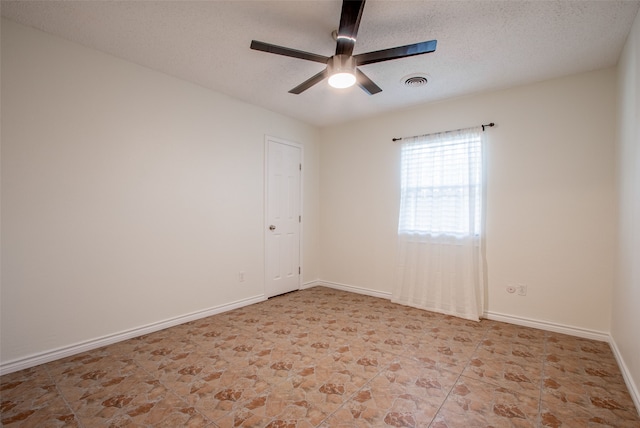 unfurnished room with ceiling fan and a textured ceiling