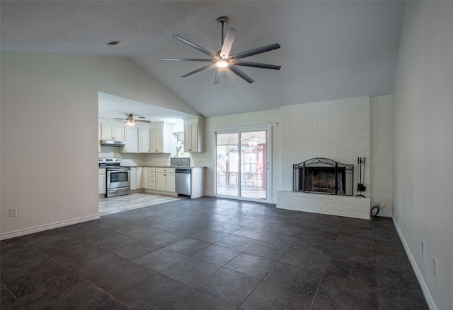 unfurnished living room with a fireplace, dark tile patterned floors, vaulted ceiling, and ceiling fan