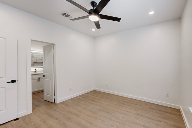 spare room with light wood-type flooring and ceiling fan