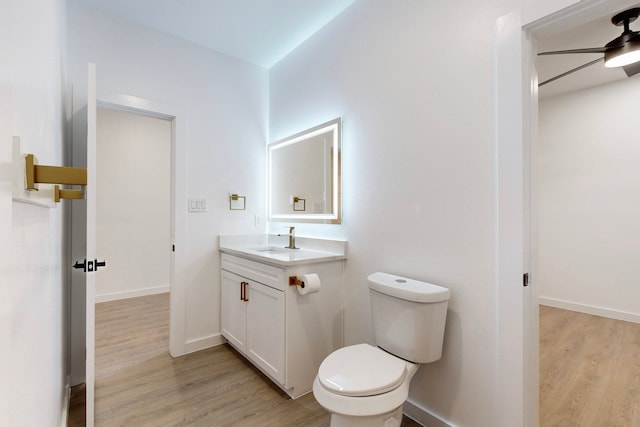 bathroom featuring vanity, hardwood / wood-style flooring, toilet, and ceiling fan