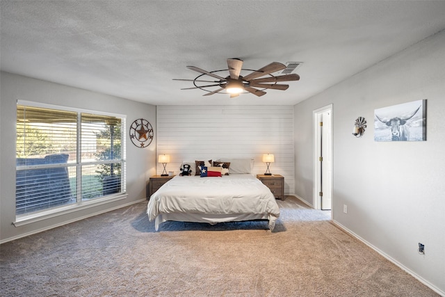 carpeted bedroom featuring a textured ceiling and ceiling fan