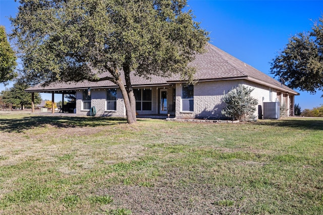 rear view of house with a lawn and cooling unit