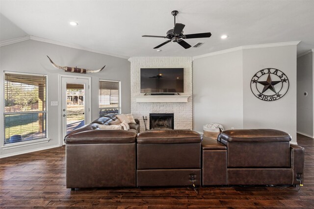 living room with ornamental molding, a brick fireplace, and dark wood-type flooring