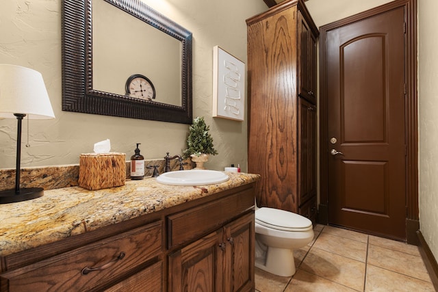 bathroom with tile patterned flooring, vanity, and toilet