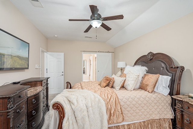 carpeted bedroom with ceiling fan, a barn door, and lofted ceiling