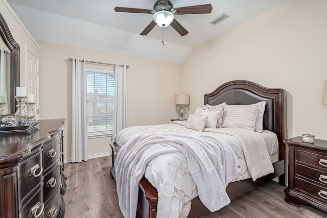 bedroom featuring light hardwood / wood-style flooring, vaulted ceiling, and ceiling fan