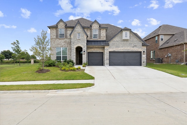 view of front of property with central air condition unit, a front yard, and a garage