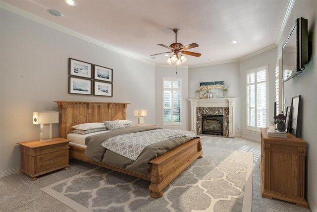 carpeted bedroom with ceiling fan, a premium fireplace, and crown molding