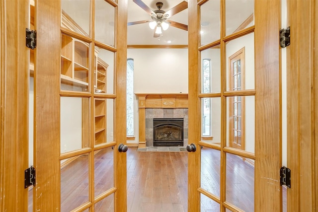 143 Coldwater Creek Ln, Weatherford, TX 76088 - unfurnished living room featuring crown molding, a tiled fireplace, hardwood / wood-style flooring, and ceiling fan