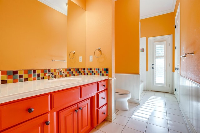 bathroom with tile patterned floors, vanity, toilet, and ornamental molding