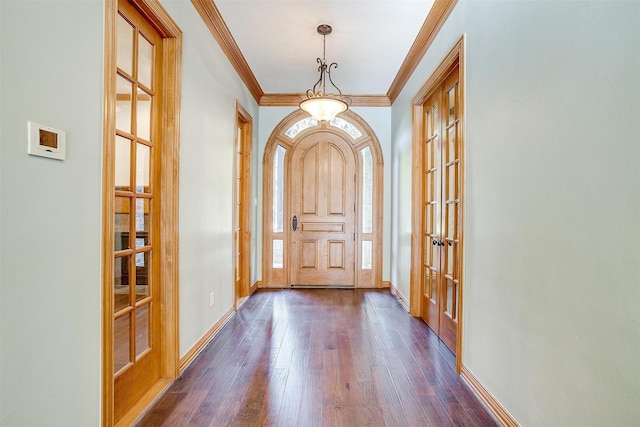 foyer entrance with ornamental molding, french doors, and dark wood-type flooring