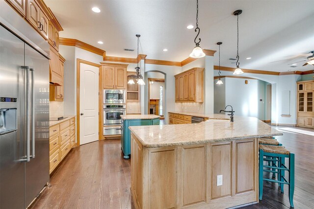 143 Coldwater Creek Ln, Weatherford, TX 76088 - kitchen featuring appliances with stainless steel finishes, arched walkways, a warming drawer, crown molding, and decorative backsplash