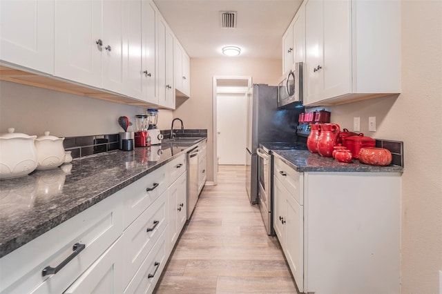 kitchen featuring light hardwood / wood-style floors, sink, white cabinetry, and stainless steel appliances