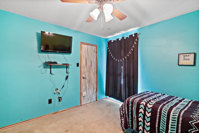 bedroom with ceiling fan, carpet floors, and a textured ceiling