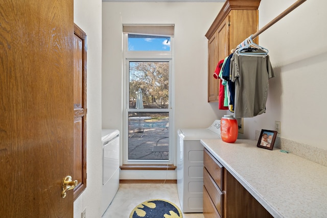 clothes washing area featuring cabinets and independent washer and dryer