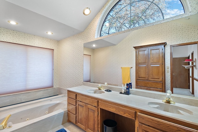 bathroom featuring vanity, vaulted ceiling, and a bathing tub