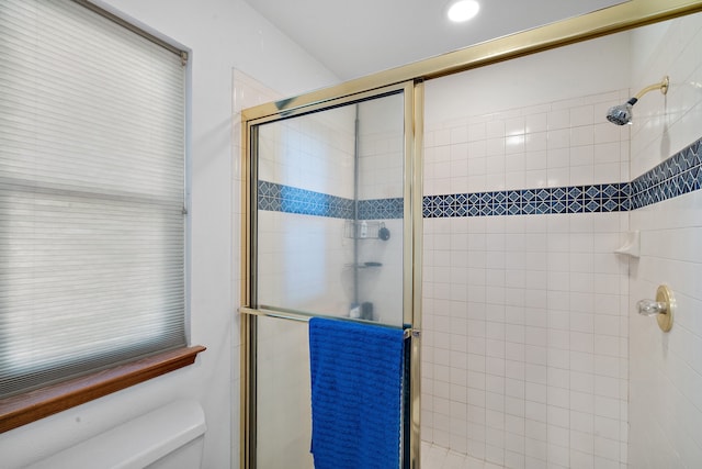 bathroom with toilet and an enclosed shower