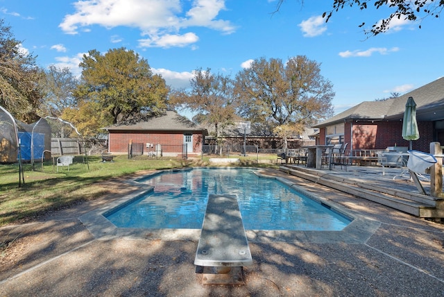 view of pool featuring a diving board, a deck, and a patio