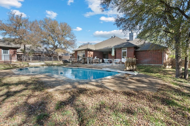 view of swimming pool featuring a diving board and a patio area