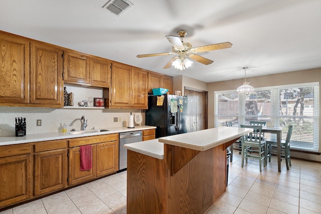 kitchen featuring pendant lighting, a center island, black fridge, sink, and stainless steel dishwasher