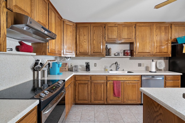 kitchen with light tile patterned floors, stainless steel appliances, range hood, and sink