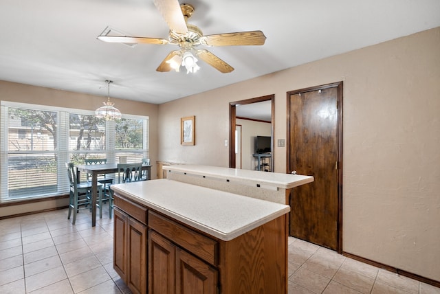 kitchen with pendant lighting, a center island, light tile patterned floors, and ceiling fan