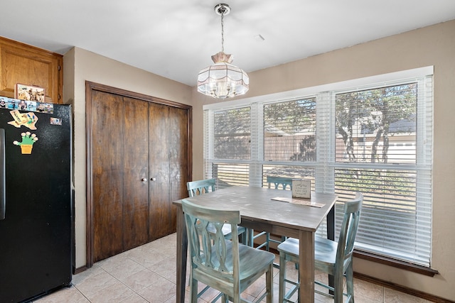 tiled dining space featuring a chandelier