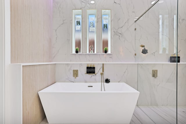 bathroom featuring a tub and tile walls