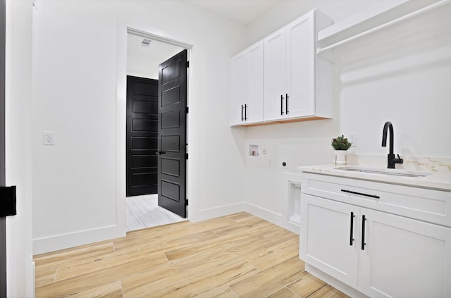 laundry room featuring sink, cabinets, light wood-type flooring, electric dryer hookup, and washer hookup