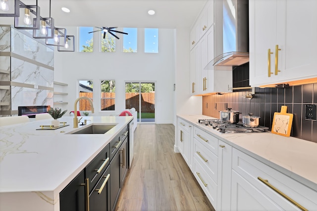 kitchen featuring white cabinetry, sink, and wall chimney exhaust hood