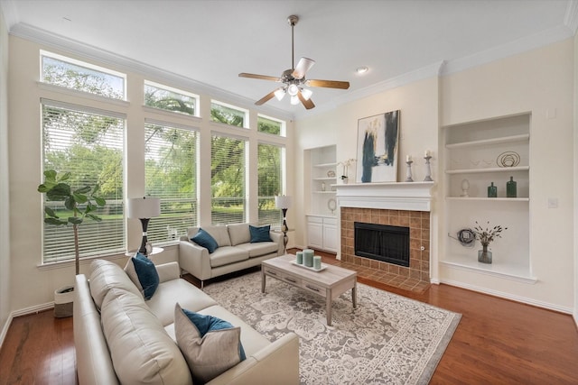 living room featuring dark hardwood / wood-style floors, a wealth of natural light, and built in shelves