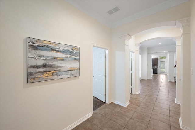 hallway with tile patterned flooring, decorative columns, and crown molding